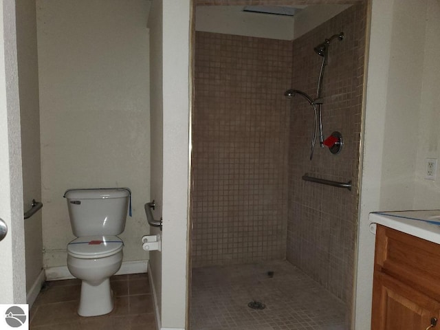 bathroom featuring tile patterned floors, toilet, vanity, and tiled shower