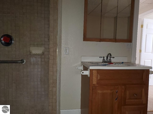 bathroom with vanity and a tile shower