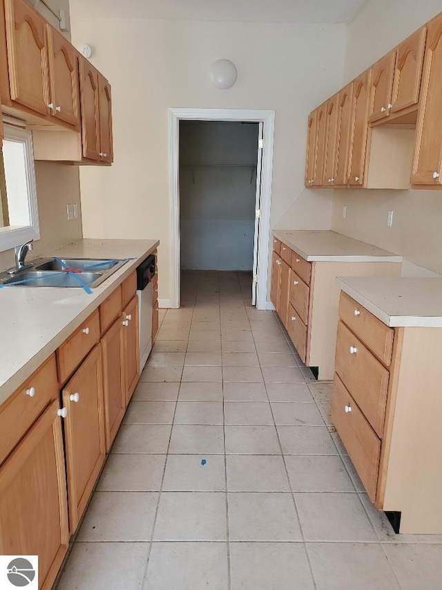 kitchen featuring sink, light tile patterned flooring, and dishwasher