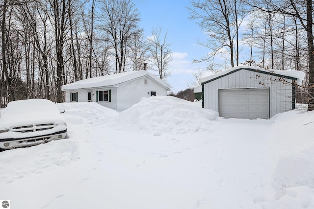 yard layered in snow with an outdoor structure and a garage