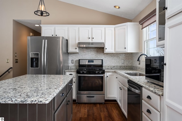 kitchen with white cabinetry, lofted ceiling, stainless steel appliances, and pendant lighting