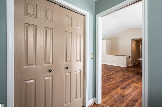 hall featuring dark hardwood / wood-style floors and lofted ceiling