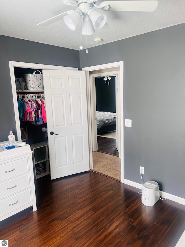 bedroom featuring ceiling fan, dark hardwood / wood-style floors, and a closet