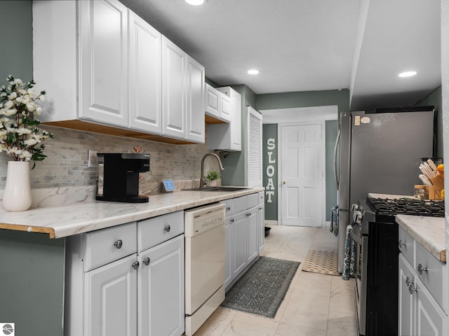 kitchen with white cabinetry, stainless steel appliances, tasteful backsplash, and sink