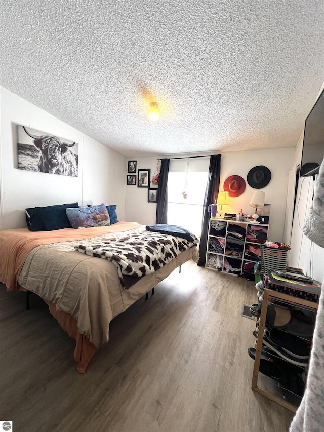 bedroom with hardwood / wood-style flooring and a textured ceiling