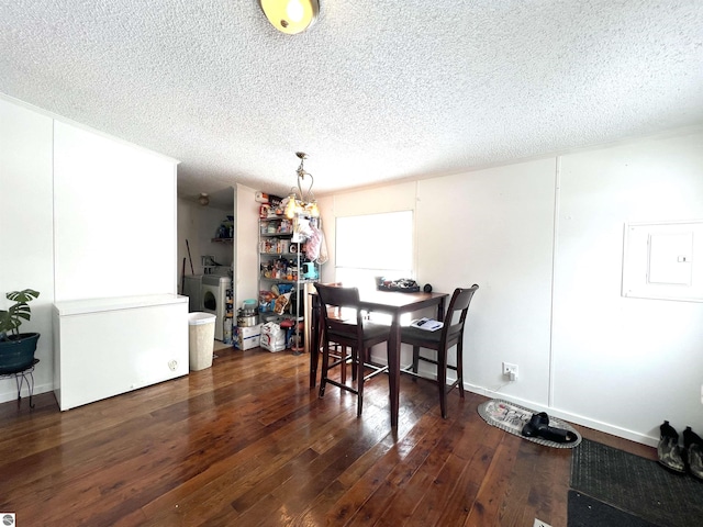 dining area with dark hardwood / wood-style flooring, washing machine and dryer, electric panel, and a textured ceiling