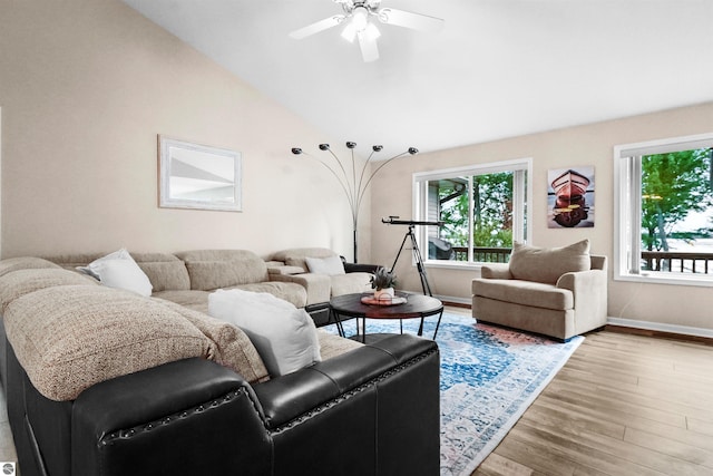 living room with ceiling fan, light wood-type flooring, and vaulted ceiling