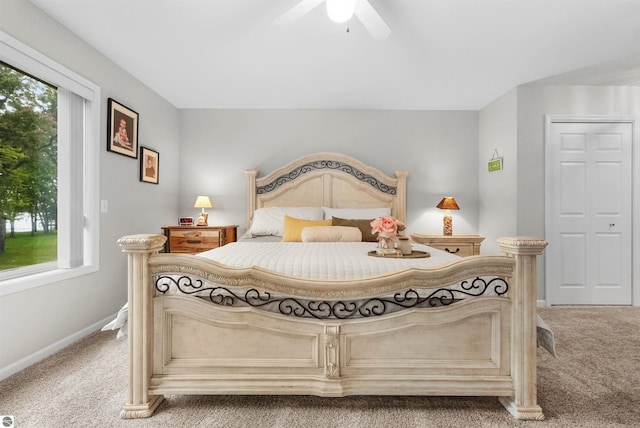 carpeted bedroom featuring multiple windows and ceiling fan