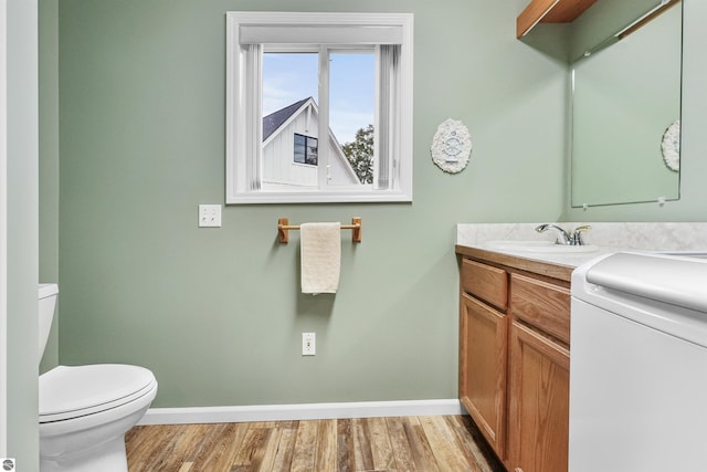 bathroom with vanity, toilet, and hardwood / wood-style floors