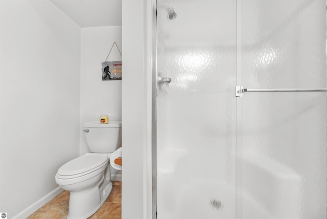 bathroom featuring tile patterned flooring, toilet, and walk in shower