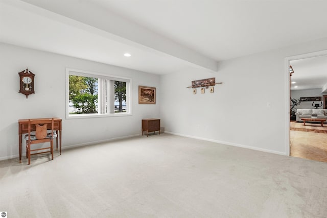 spare room featuring beam ceiling and carpet