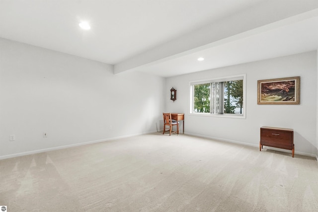 carpeted empty room featuring beamed ceiling