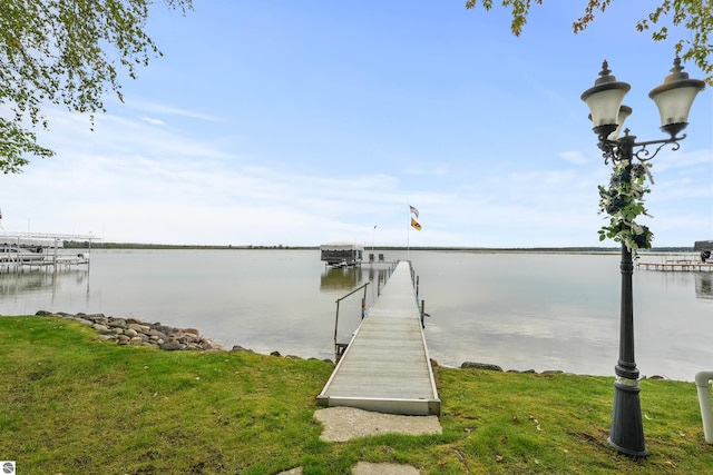 view of dock featuring a water view and a lawn