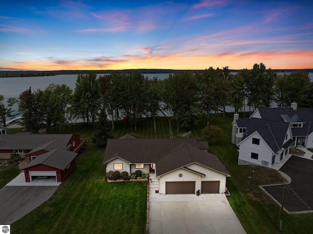 aerial view at dusk featuring a water view