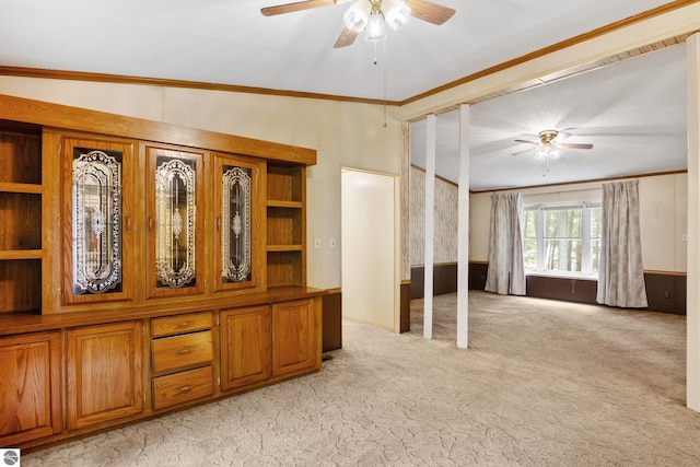 interior space with ceiling fan and crown molding