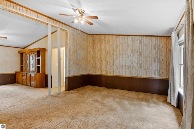 carpeted empty room featuring ornamental molding and ceiling fan