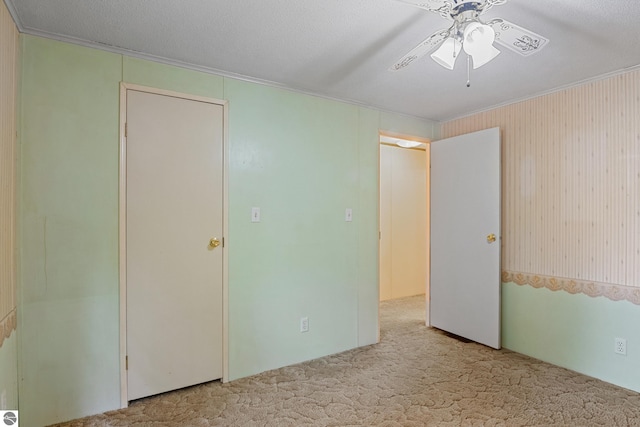 unfurnished bedroom featuring a textured ceiling, light carpet, and ceiling fan