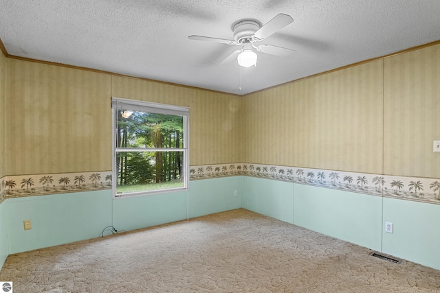 empty room with a textured ceiling, carpet flooring, and ceiling fan