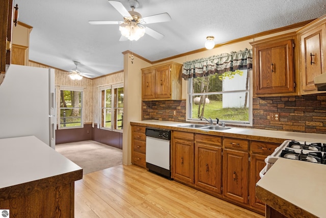 kitchen with white appliances, lofted ceiling, sink, light hardwood / wood-style floors, and crown molding