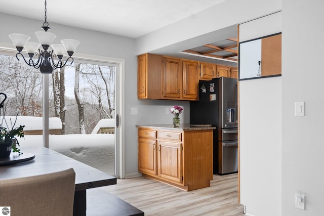 kitchen featuring a chandelier, pendant lighting, stainless steel fridge, coffered ceiling, and light hardwood / wood-style floors