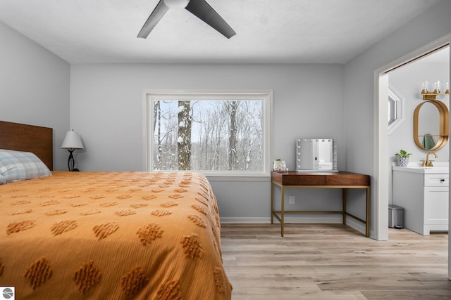 bedroom featuring ceiling fan, sink, and light hardwood / wood-style flooring