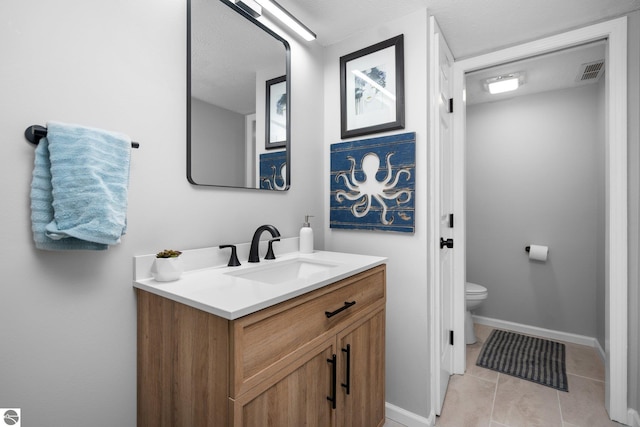 bathroom featuring tile patterned floors, vanity, and toilet