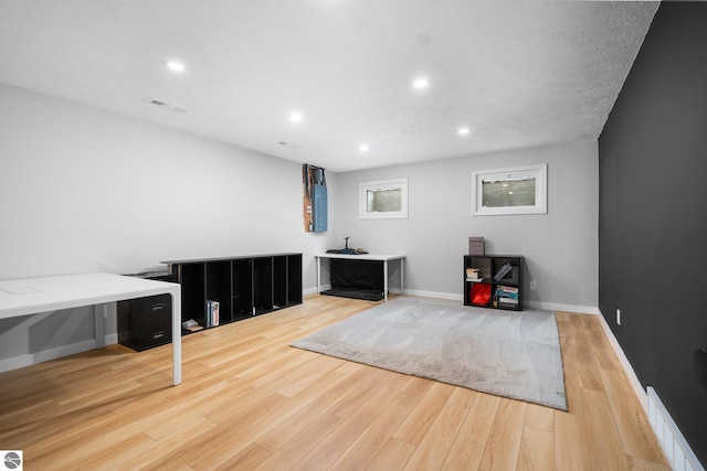 interior space with a textured ceiling and light wood-type flooring