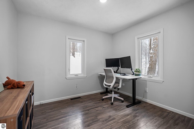 office space with a healthy amount of sunlight and dark hardwood / wood-style flooring