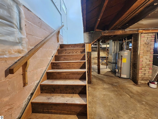 stairs with water heater, concrete floors, and heating unit