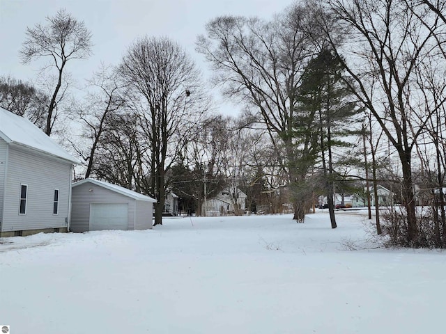 snowy yard with a garage