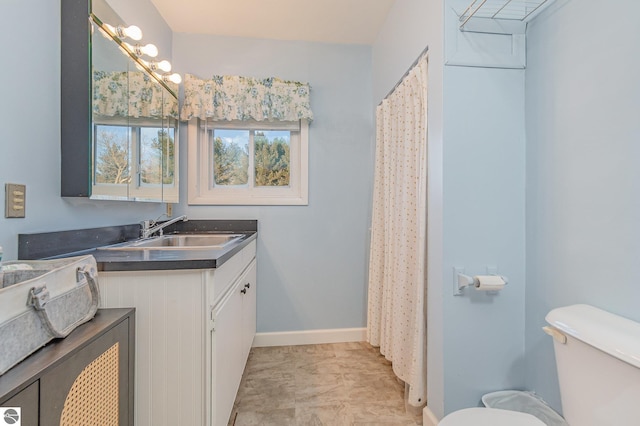 full bathroom with toilet, baseboards, and vanity