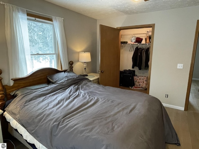 bedroom featuring a textured ceiling, a closet, and baseboards