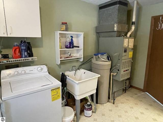 washroom featuring light floors, cabinet space, washer / dryer, and baseboards