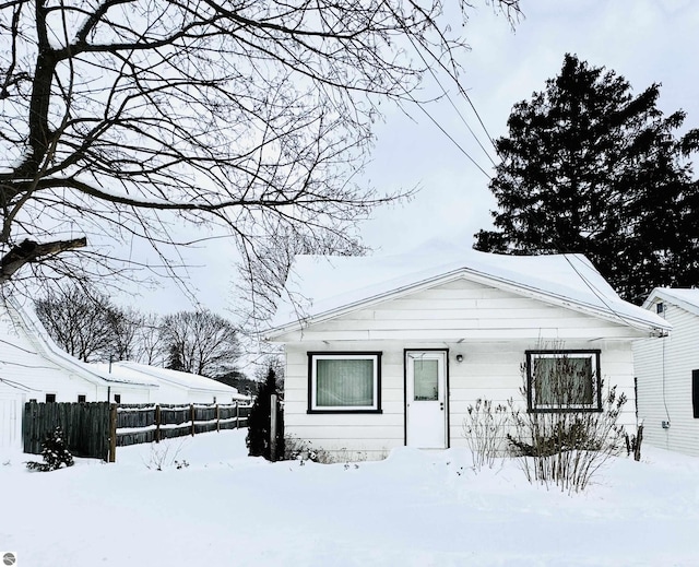 bungalow-style home featuring fence