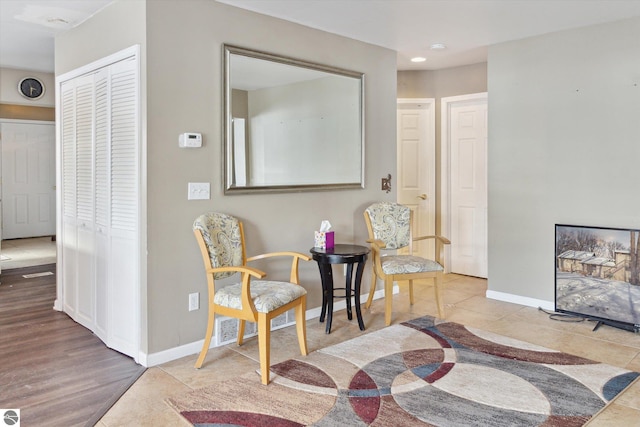 sitting room featuring tile patterned flooring, a fireplace, and baseboards