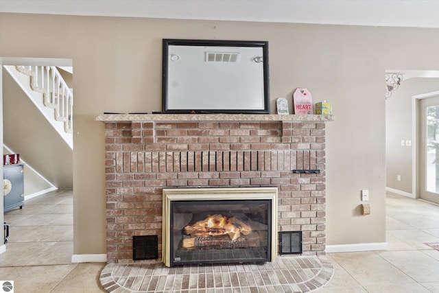 details with a fireplace, visible vents, and baseboards