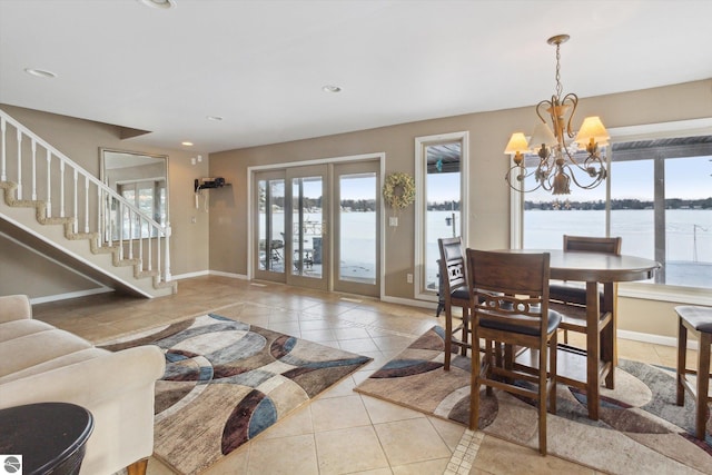 dining space with baseboards, stairway, a water view, a chandelier, and light tile patterned flooring