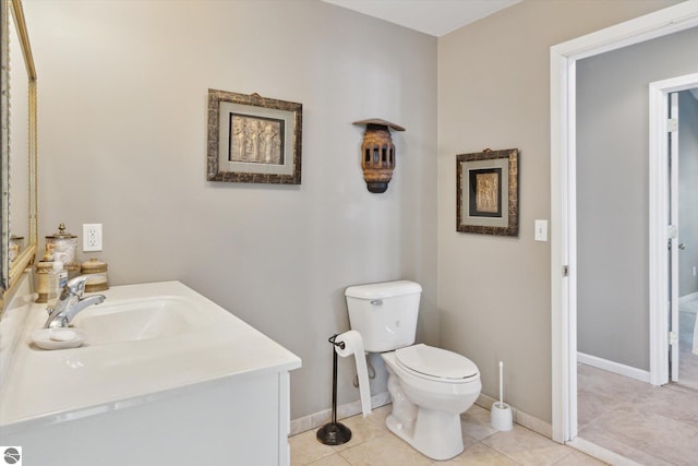 bathroom with toilet, vanity, baseboards, and tile patterned floors