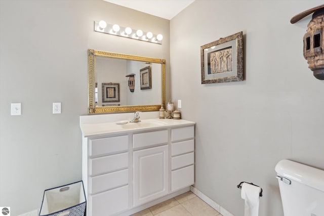 bathroom featuring toilet, tile patterned flooring, baseboards, and vanity