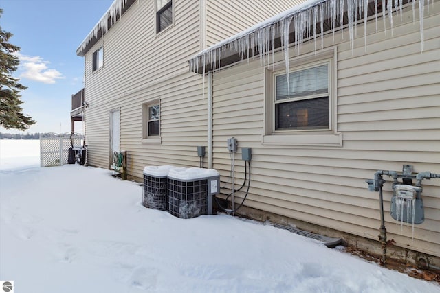 snow covered property featuring cooling unit