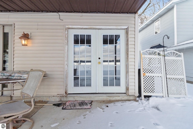 snow covered property entrance with french doors