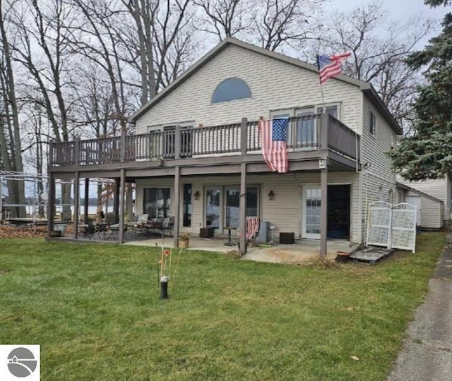 rear view of house featuring a yard, a patio area, and a wooden deck