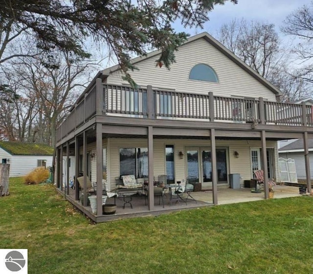 back of house with outdoor lounge area, a deck, a lawn, and a patio