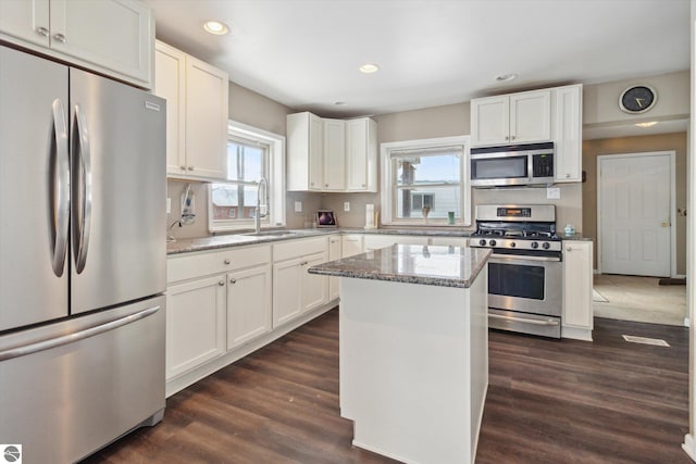 kitchen featuring white cabinetry, appliances with stainless steel finishes, light stone counters, and a sink