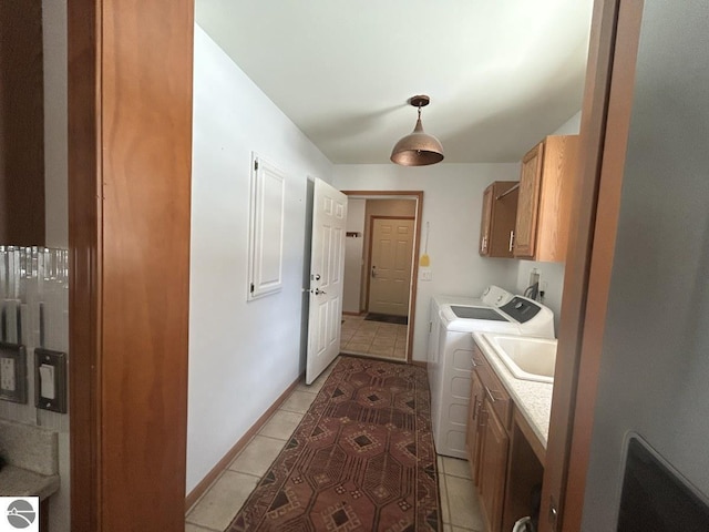 laundry room with cabinet space, independent washer and dryer, baseboards, and light tile patterned floors