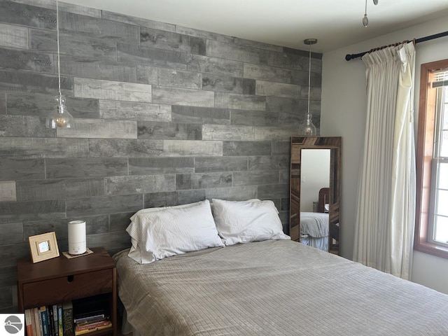 bedroom with an accent wall and tile walls