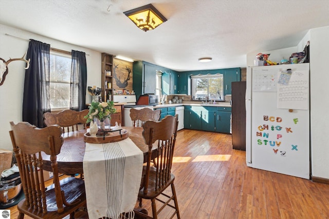 dining area featuring a textured ceiling and light wood-type flooring