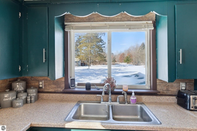 kitchen with light countertops, a sink, and green cabinetry