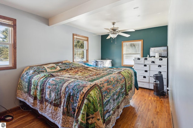 bedroom featuring light wood-style floors, beam ceiling, and ceiling fan