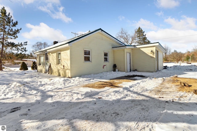 view of snow covered back of property